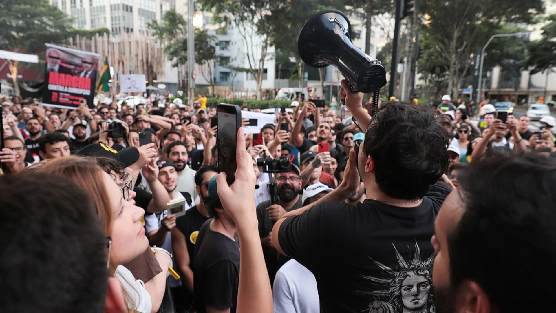 Renan Santos discursando com megafone para apoiadores